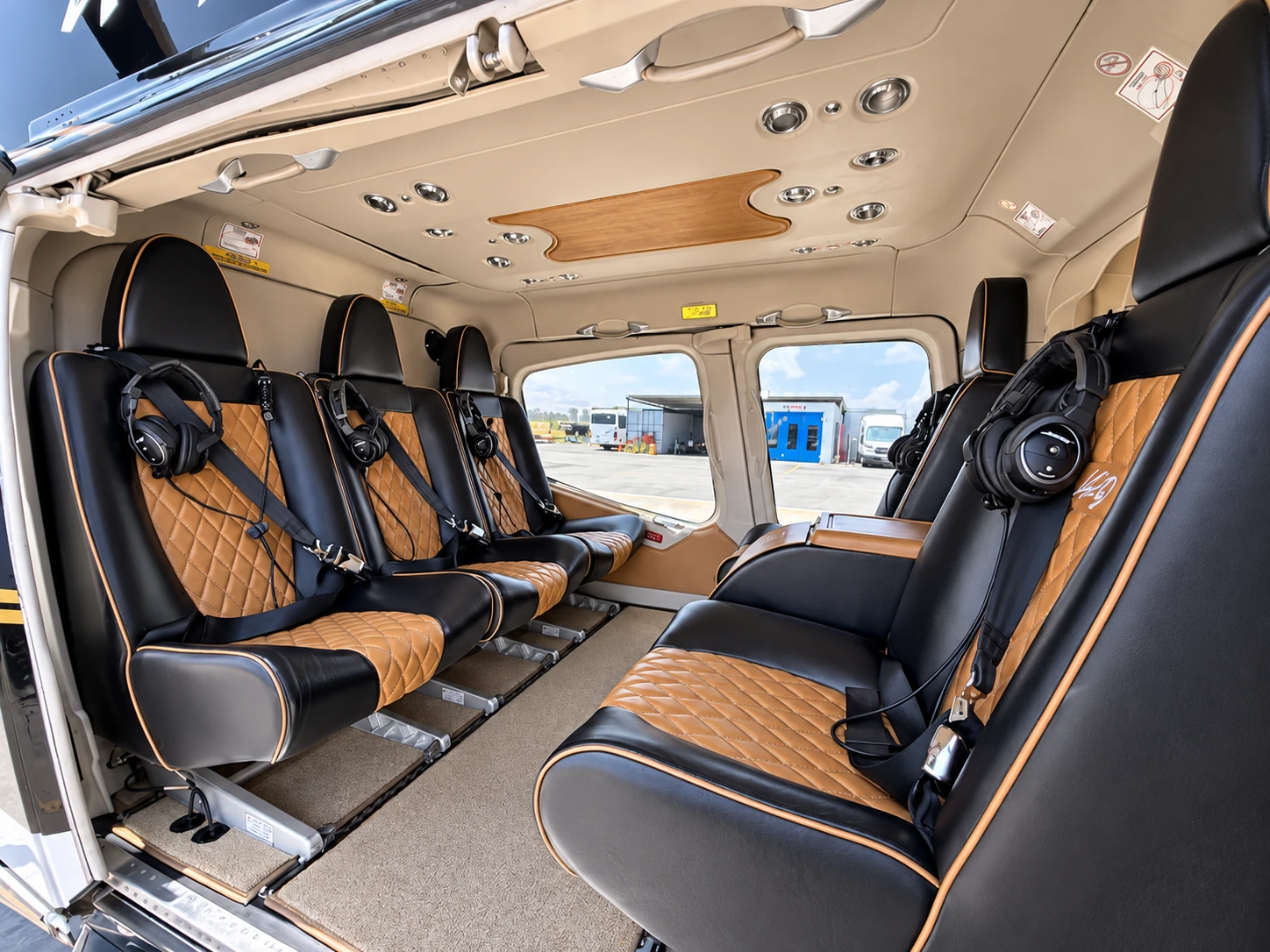 Spacious helicopter cabin with tan leather passenger seats