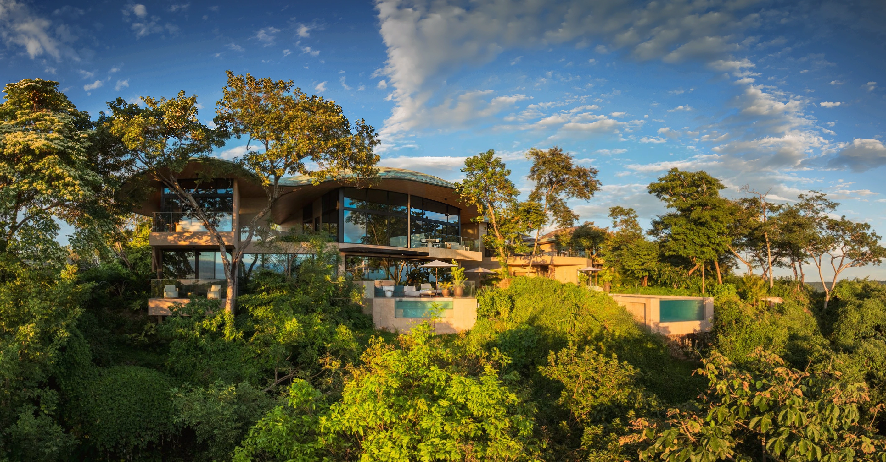 AI-enhanced photograph of the Sculpted Bayview Villa's curving roof and terraces on a wooded hillside