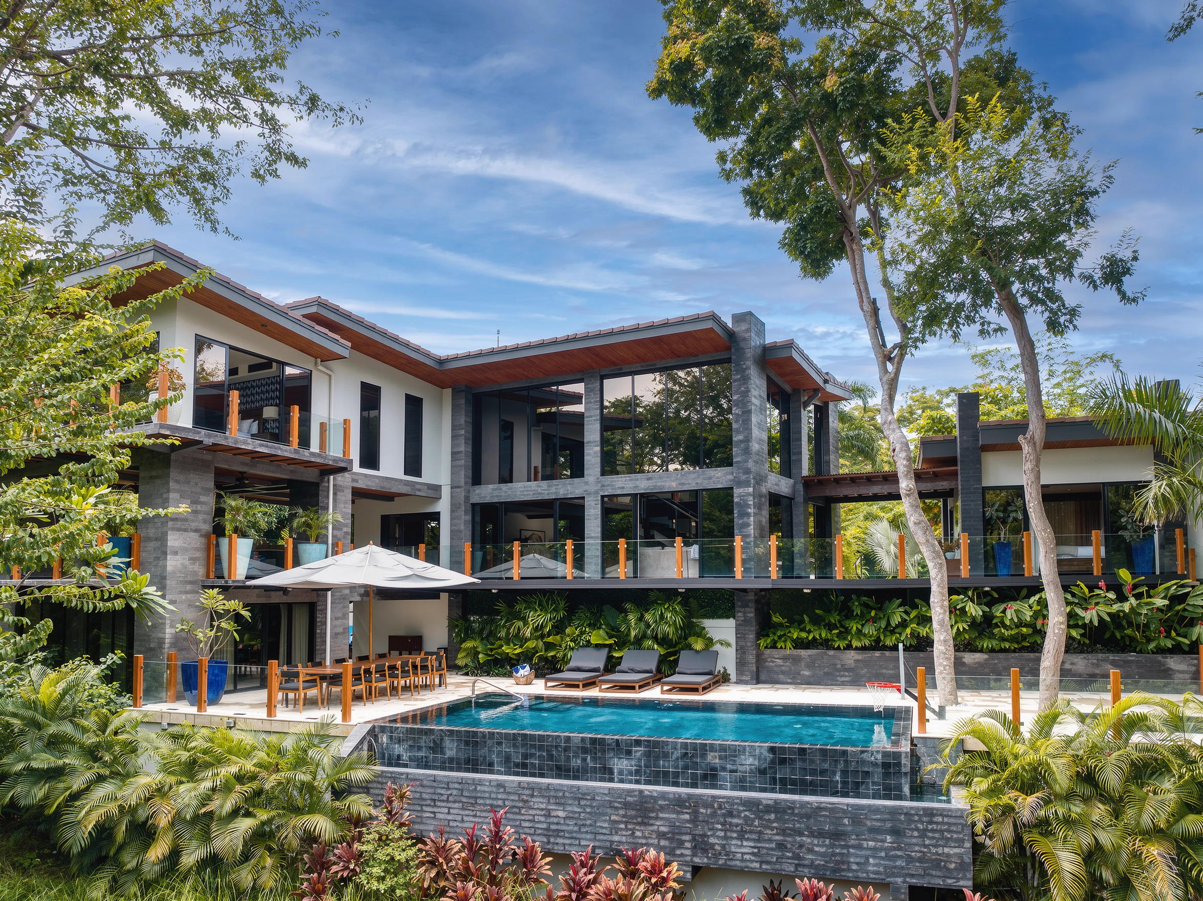 AI-enhanced photograph of the Tropical Pool Villa with timber rooflines, a private pool and tropical greenery