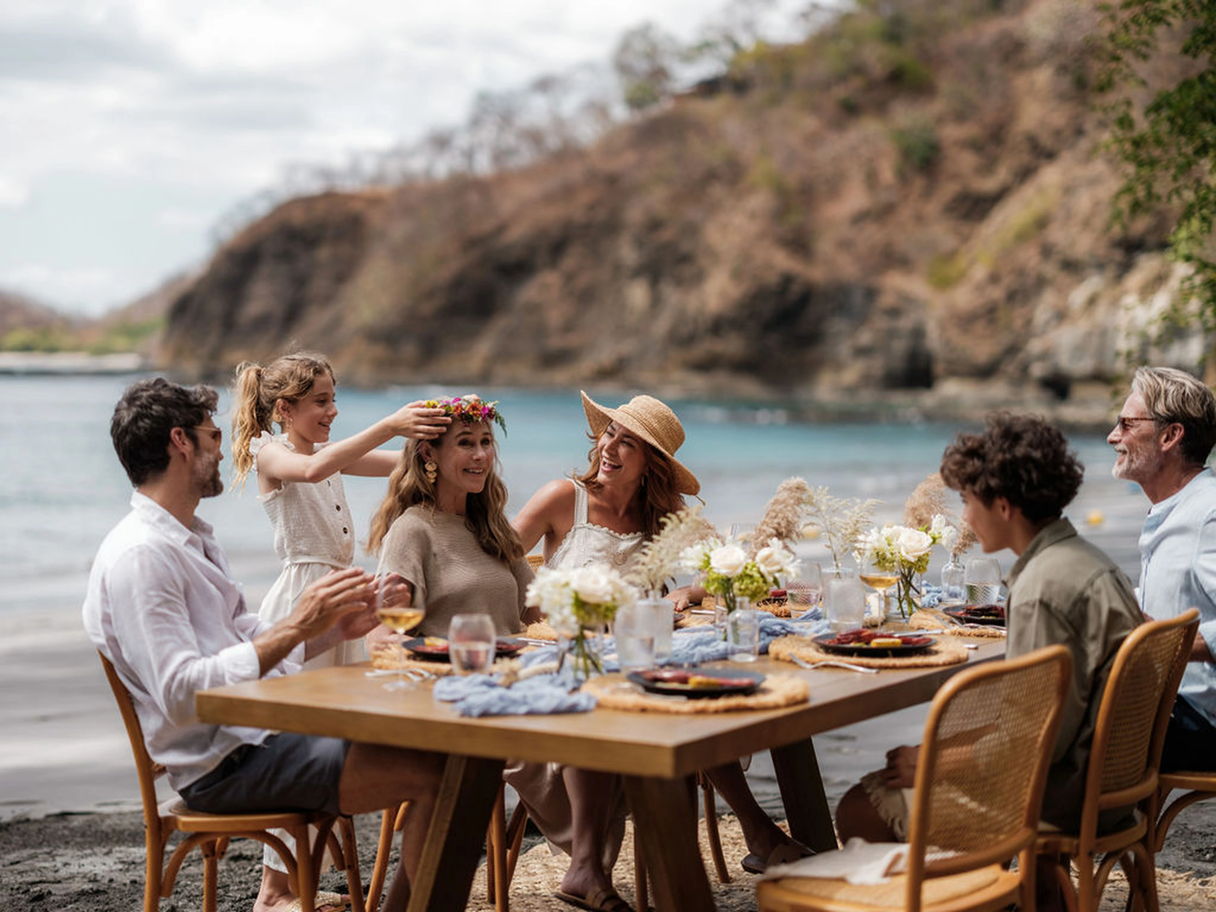 Guests enjoying a meal together beside the coast